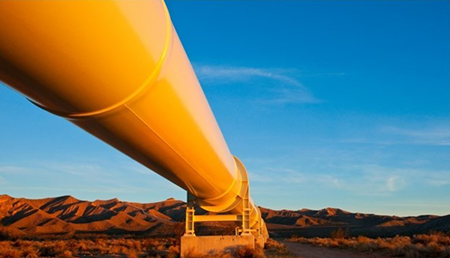 Yellow pipeline across a desert landscape with a mountain backdrop