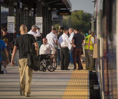 A man in a wheelchair exits a metro-car.